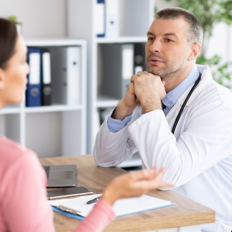 male-experienced-doctor-talking-to-his-female-patient